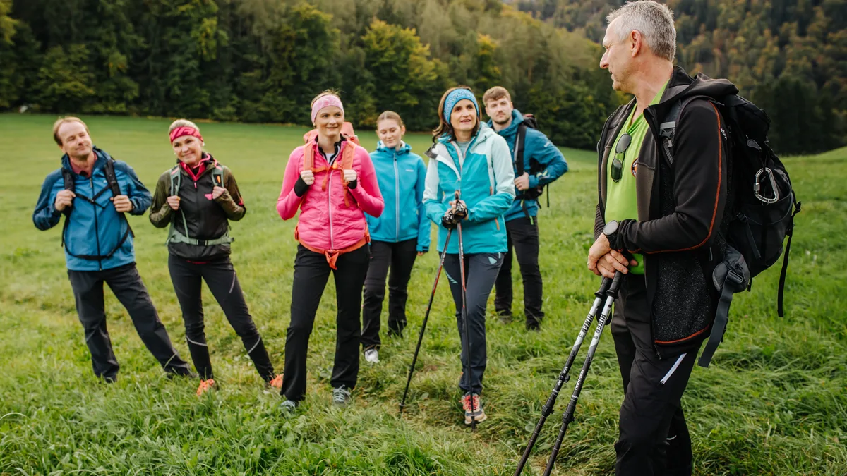 Andreas Kohlbacher mit einer Wandergruppe auf einer Wiese in der Weststeiermark